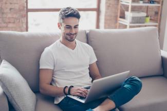 man sitting on couch with a laptop