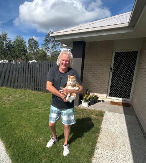 Jim outside his home with a cat