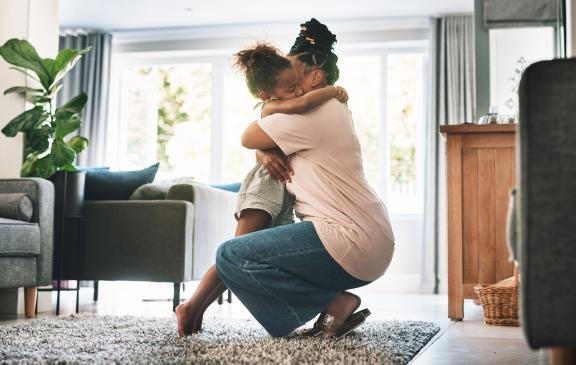 mother and daughter embracing in a living room